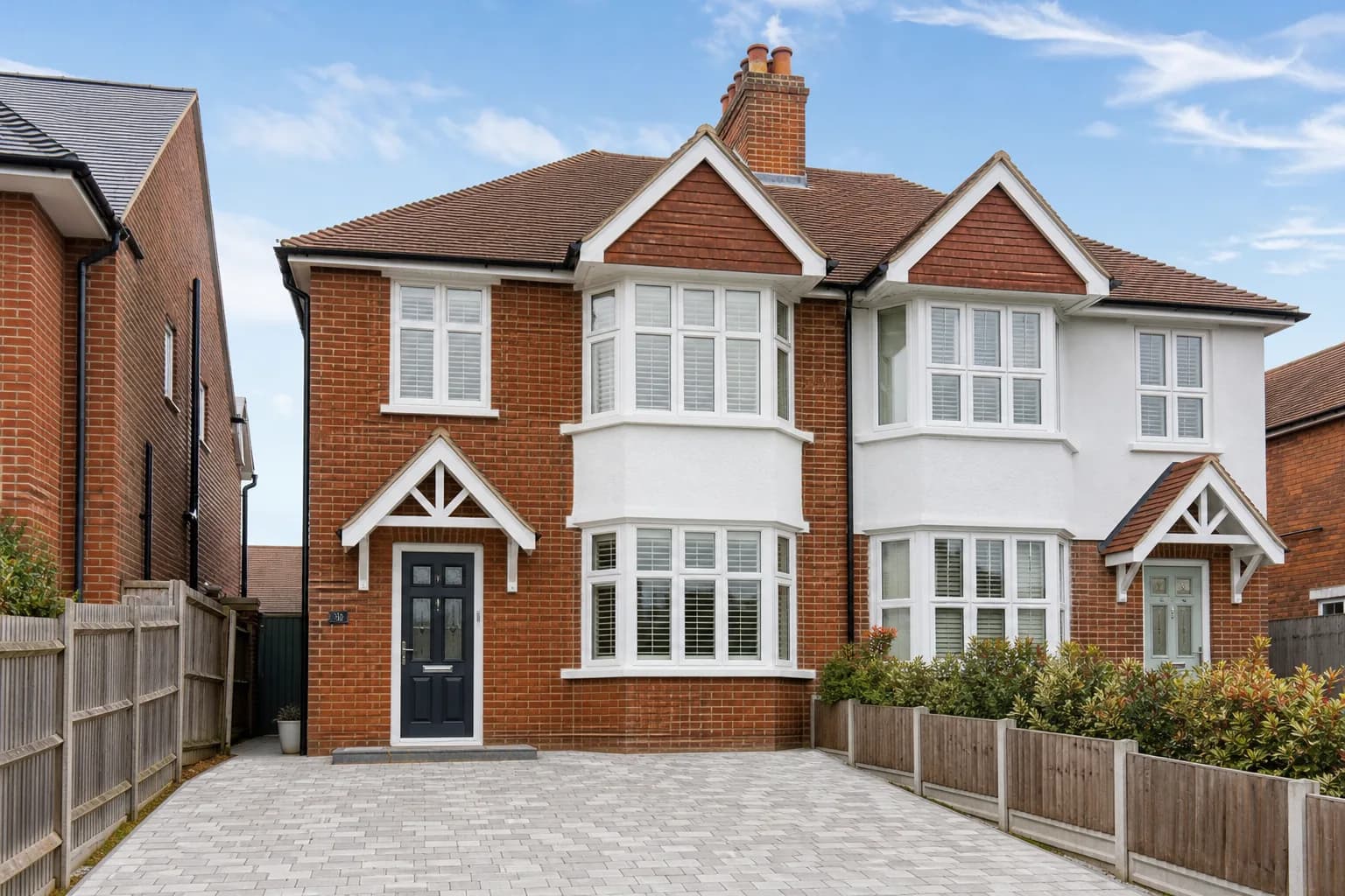 Exterior of a well-maintained British semi-detached house with freshly pointed brickwork and tidy rooflines