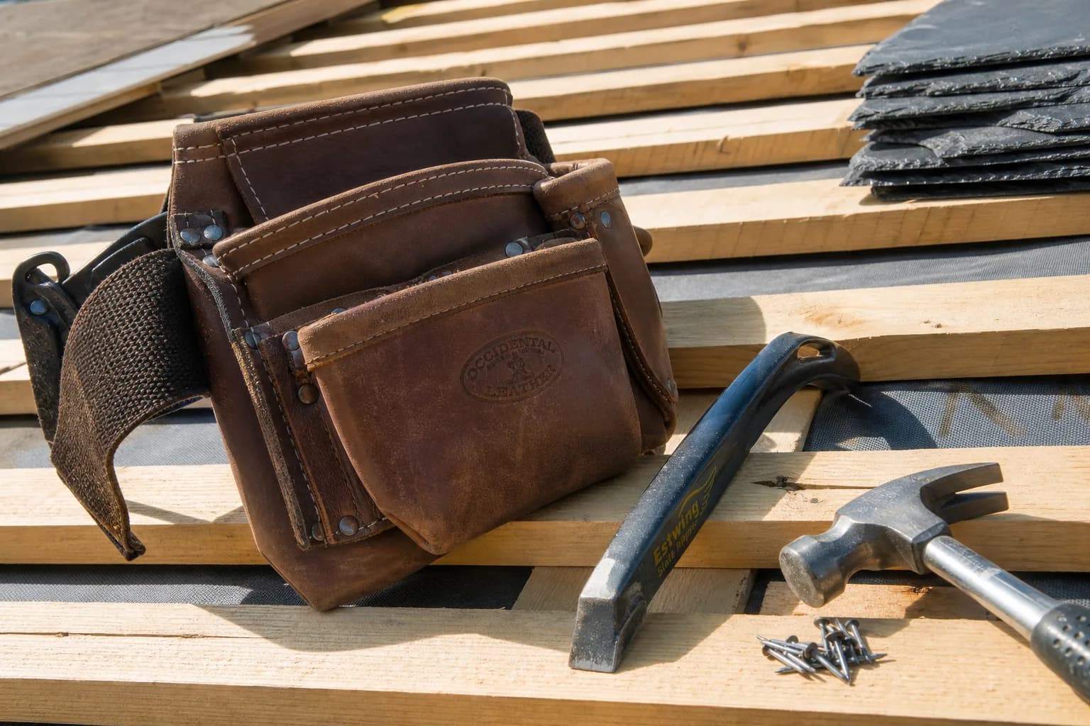 A roofer's tool belt and tools resting on new roof battens